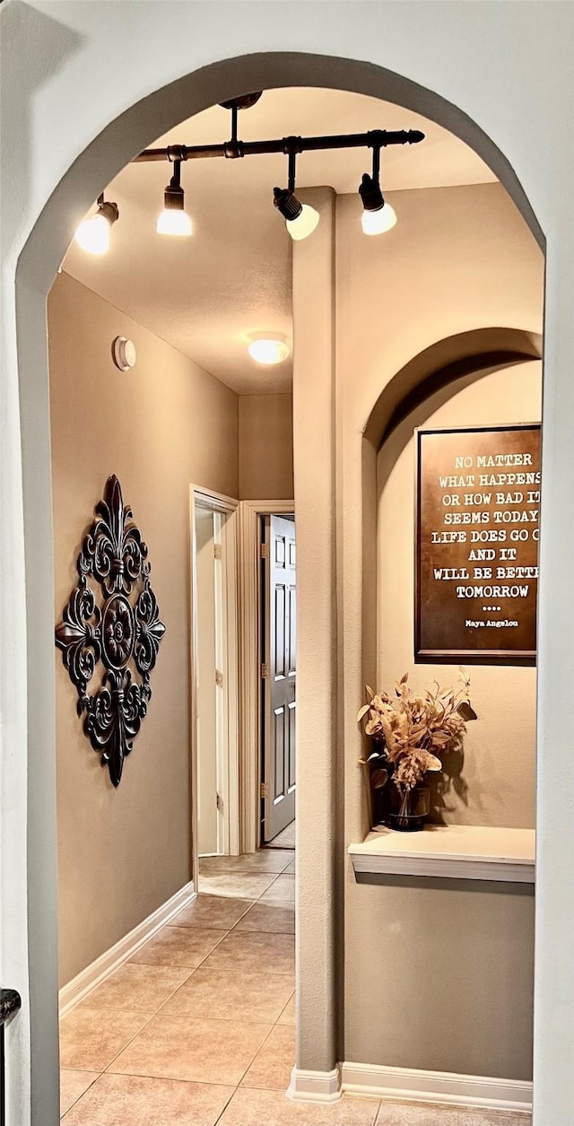 8423 Glenn Leigh Dr NE, Spring, TX 77379 - hall featuring arched walkways, tile patterned flooring, and baseboards