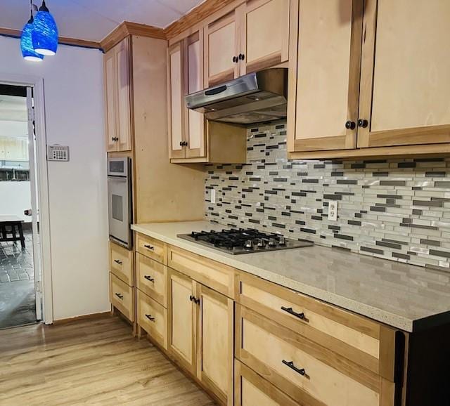 9719 Lawngate Dr, Houston, TX 77080 - kitchen with appliances with stainless steel finishes, under cabinet range hood, tasteful backsplash, and light wood finished floors