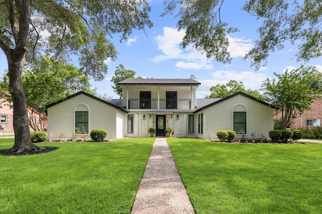 15414 Ashburton Dr, Jersey Village, TX 77040 - view of front of home with a balcony, a front lawn, brick siding, and a chimney