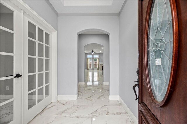 4130 Tree Moss Pl, Humble, TX 77346 - foyer with baseboards, arched walkways, marble look tile flooring, and french doors