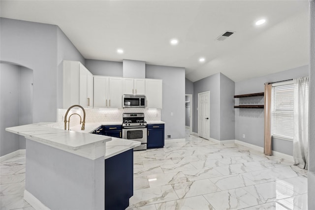 4130 Tree Moss Pl, Humble, TX 77346 - kitchen featuring appliances with stainless steel finishes, blue cabinetry, light marble finish floors, light stone countertops, and white cabinetry