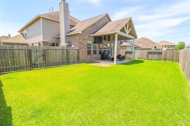 9911 Clear Diamond Dr, Rosharon, TX 77583 - back of house featuring brick siding, a patio, a chimney, and roof with shingles