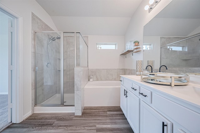 20231 Creekdale Bend Dr, Cypress, TX 77433 - bathroom featuring a garden tub, double vanity, a shower stall, vaulted ceiling, and wood finished floors