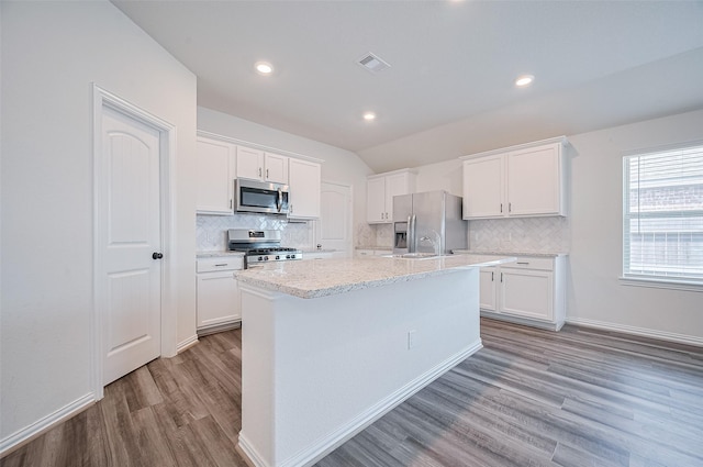 20231 Creekdale Bend Dr, Cypress, TX 77433 - kitchen featuring stainless steel appliances, wood finished floors, tasteful backsplash, white cabinets, and lofted ceiling