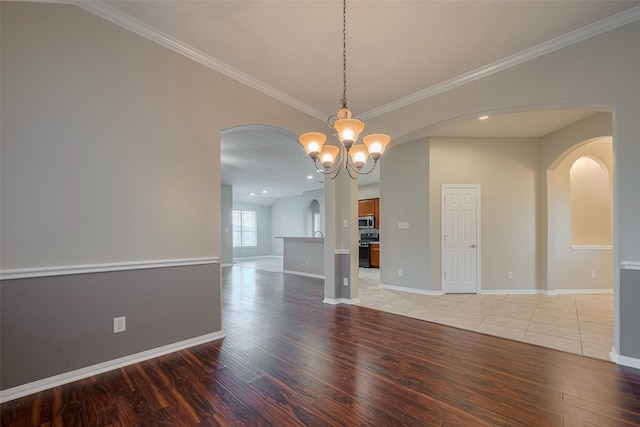 13409 Timberoak Ct, Rosharon, TX 77583 - empty room featuring arched walkways, light wood-type flooring, baseboards, crown molding, and a chandelier