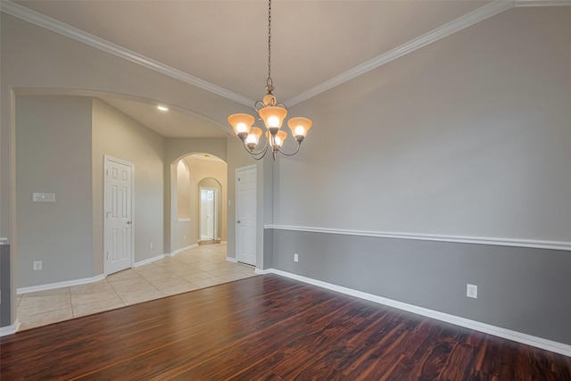 13409 Timberoak Ct, Rosharon, TX 77583 - empty room featuring arched walkways, wood finished floors, a chandelier, baseboards, and ornamental molding
