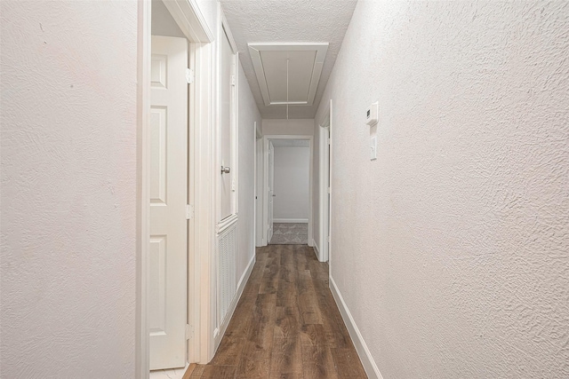 12111 Jutland Rd, Houston, TX 77048 - hall featuring attic access, a textured wall, wood finished floors, baseboards, and a textured ceiling