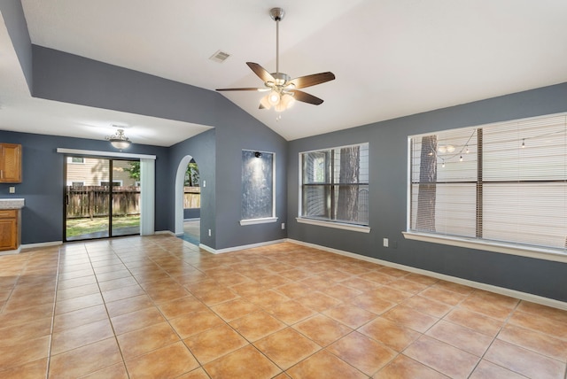 14 W Cobble Hill Cir, The Woodlands, TX 77381 - unfurnished living room with ceiling fan, arched walkways, light tile patterned floors, vaulted ceiling, and baseboards
