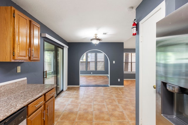 14 W Cobble Hill Cir, The Woodlands, TX 77381 - kitchen featuring stainless steel appliances, light tile patterned flooring, brown cabinetry, and baseboards