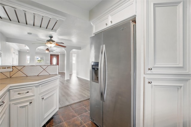 1118 Hammock St, Houston, TX 77009 - kitchen with stainless steel fridge with ice dispenser, arched walkways, a ceiling fan, backsplash, and white cabinetry