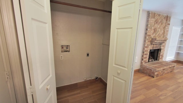 1203 Brook Grove Dr, Katy, TX 77450 - washroom featuring hookup for an electric dryer, washer hookup, wood finished floors, a fireplace, and baseboards