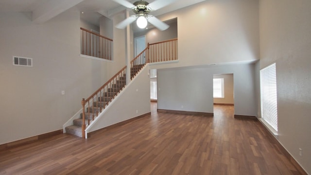 1203 Brook Grove Dr, Katy, TX 77450 - unfurnished living room featuring a ceiling fan, wood finished floors, stairs, a high ceiling, and baseboards
