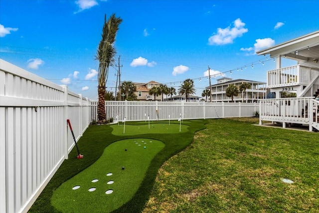 3931 Fort Bend Dr, Galveston, TX 77554 - view of yard featuring a putting green, stairway, and a deck