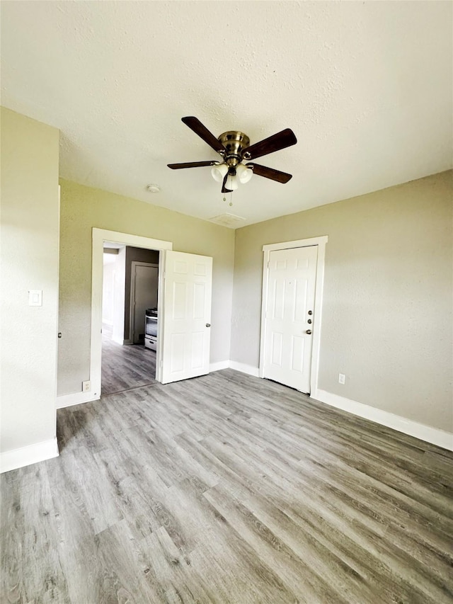 609 Martin Luther King Jr Blvd, Corsicana, TX 75110 - empty room with wood finished floors, baseboards, ceiling fan, and a textured ceiling