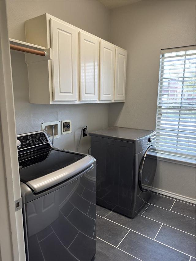 2406 Meadow Tree Ln, Spring, TX 77388 - laundry area featuring cabinet space, plenty of natural light, dark tile patterned flooring, and separate washer and dryer