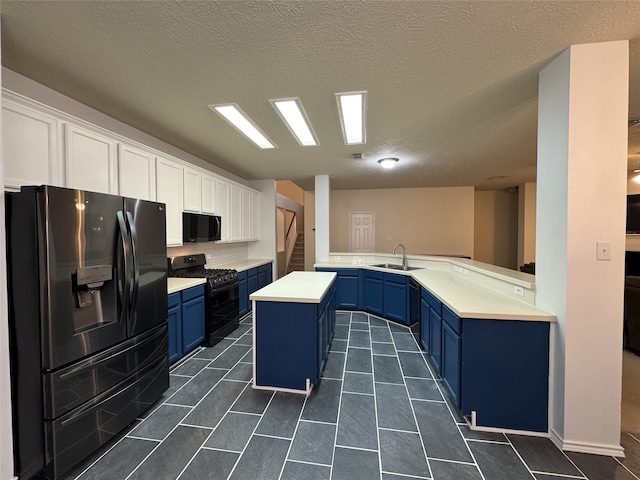 2406 Meadow Tree Ln, Spring, TX 77388 - kitchen with black appliances, blue cabinetry, a sink, light countertops, and white cabinetry