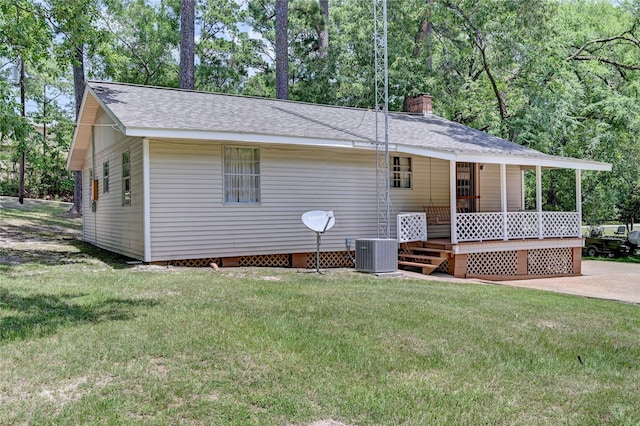 6 Hickory Holw, Huntsville, TX 77320 - view of front of home featuring central AC, covered porch, a front lawn, and a chimney