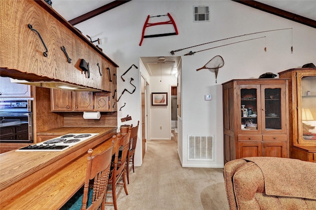 6 Hickory Holw, Huntsville, TX 77320 - kitchen with white electric cooktop, oven, light colored carpet, brown cabinetry, and lofted ceiling