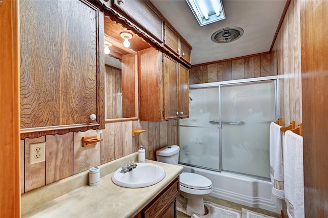 6 Hickory Holw, Huntsville, TX 77320 - full bathroom featuring toilet, bath / shower combo with glass door, vanity, and wooden walls