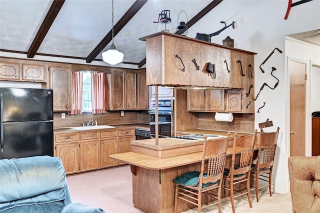 6 Hickory Holw, Huntsville, TX 77320 - kitchen featuring freestanding refrigerator, multiple ovens, beam ceiling, light colored carpet, and a peninsula