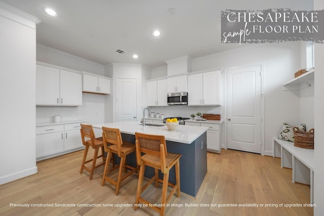 1816 Colquitt St, Houston, TX 77098 - kitchen with stainless steel microwave, a sink, ornamental molding, white cabinetry, and light wood finished floors