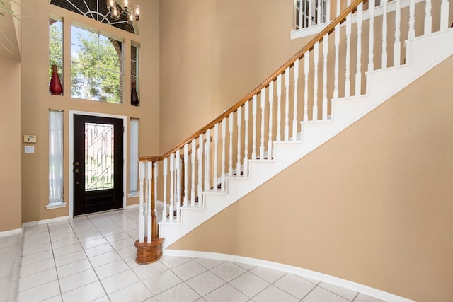 3915 Garnet Fls, Sugar Land, TX 77479 - tiled entryway featuring a towering ceiling, baseboards, a chandelier, and stairs