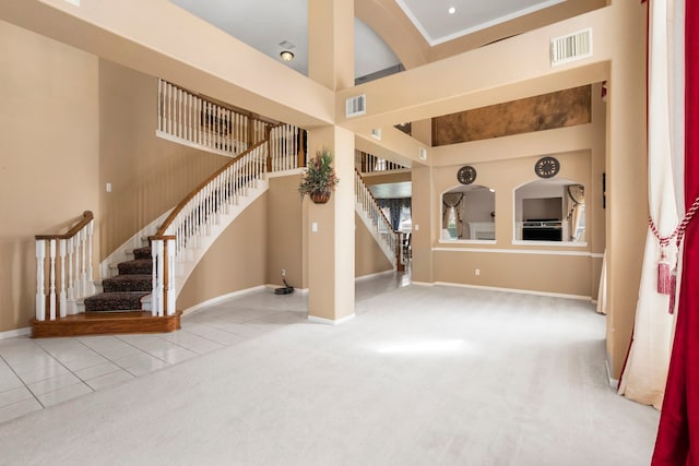 3915 Garnet Fls, Sugar Land, TX 77479 - unfurnished living room with stairs, a towering ceiling, baseboards, carpet, and tile patterned floors
