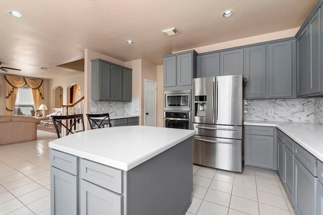 3915 Garnet Fls, Sugar Land, TX 77479 - kitchen with stainless steel appliances, gray cabinets, open floor plan, light tile patterned floors, and backsplash