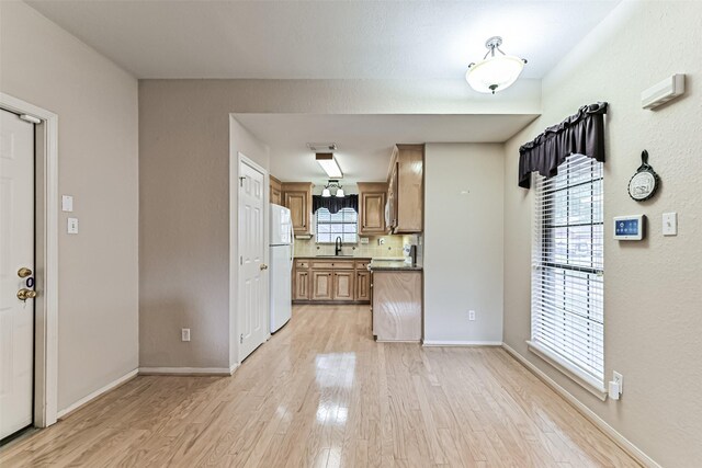 404 Live Oak Ln, Friendswood, TX 77546 - kitchen featuring freestanding refrigerator, light wood finished floors, tasteful backsplash, and baseboards