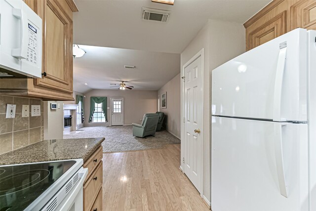 404 Live Oak Ln, Friendswood, TX 77546 - kitchen featuring white appliances, light wood finished floors, ceiling fan, dark stone countertops, and a fireplace