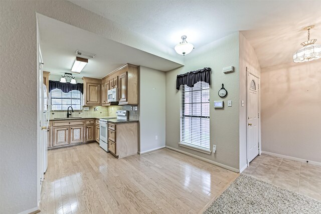 404 Live Oak Ln, Friendswood, TX 77546 - kitchen featuring white appliances, light wood finished floors, baseboards, a sink, and backsplash