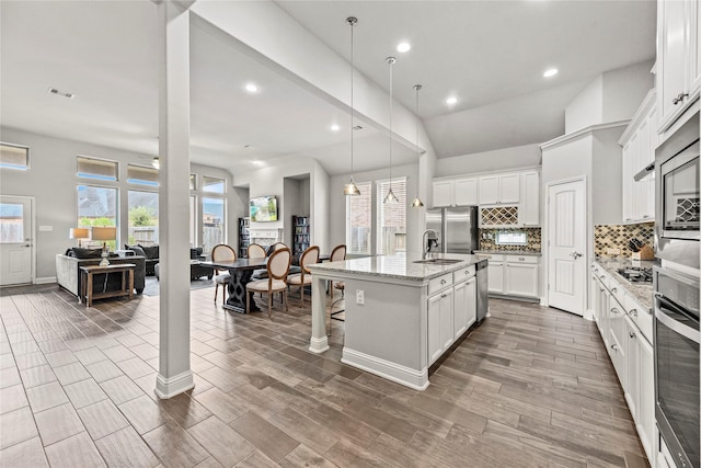 18810 Peachleaf Willow Trce, Cypress, TX 77429 - kitchen featuring stainless steel appliances, decorative backsplash, a breakfast bar area, recessed lighting, and a center island with sink