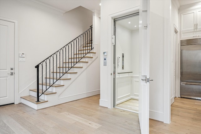 213 Sutton Row Pl, Houston, TX 77024 - stairway featuring crown molding, wood finished floors, baseboards, and a decorative wall