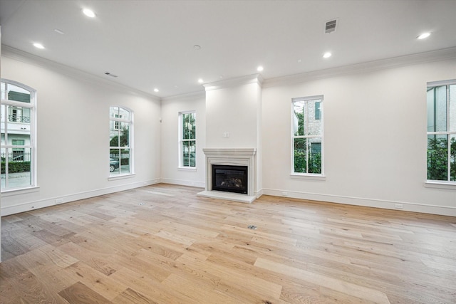 213 Sutton Row Pl, Houston, TX 77024 - unfurnished living room with plenty of natural light, light wood-type flooring, recessed lighting, a glass covered fireplace, and ornamental molding
