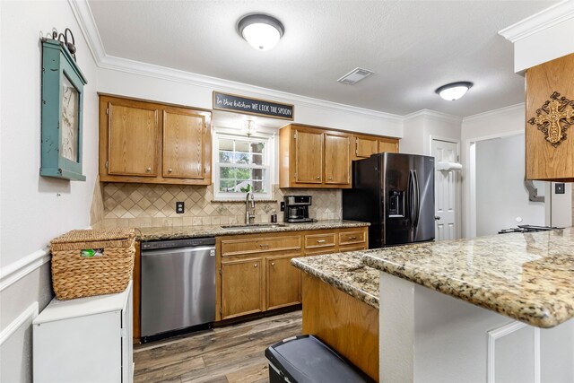 3303 Indian Mound Trl, Crosby, TX 77532 - kitchen featuring stainless steel dishwasher, a sink, black fridge, wood finished floors, and a peninsula