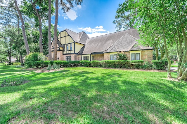 9911 Oxted Ln, Spring, TX 77379 - tudor house featuring brick siding, a front yard, and a shingled roof