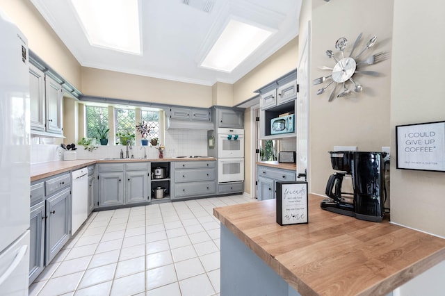 9911 Oxted Ln, Spring, TX 77379 - kitchen featuring gray cabinetry, white appliances, butcher block counters, a sink, and backsplash