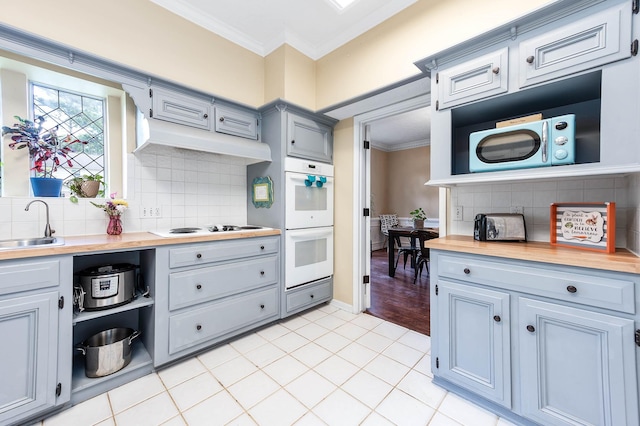 9911 Oxted Ln, Spring, TX 77379 - kitchen featuring ornamental molding, white appliances, tasteful backsplash, butcher block countertops, and light tile patterned floors