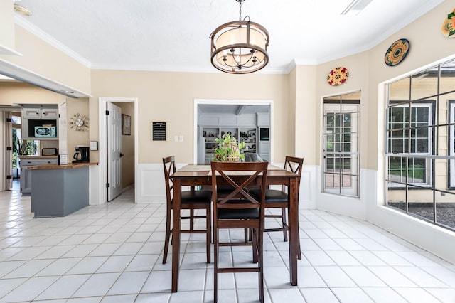 9911 Oxted Ln, Spring, TX 77379 - dining room featuring crown molding, a chandelier, light tile patterned floors, a wainscoted wall, and a decorative wall