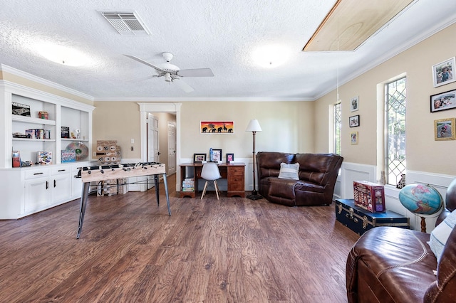 9911 Oxted Ln, Spring, TX 77379 - living area featuring dark wood-style floors, a desk, ceiling fan, a wainscoted wall, and ornamental molding