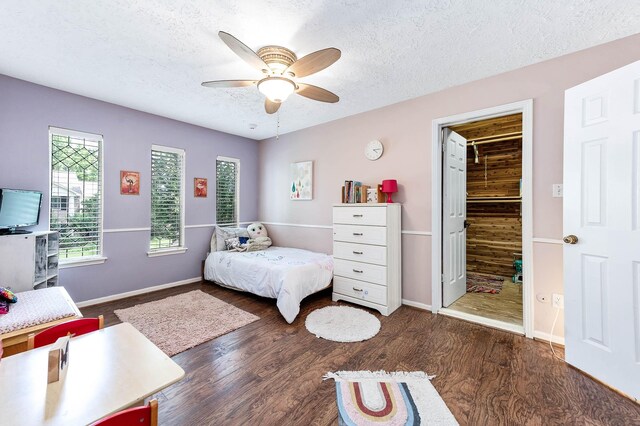 9911 Oxted Ln, Spring, TX 77379 - bedroom featuring a textured ceiling, wood finished floors, baseboards, and ceiling fan