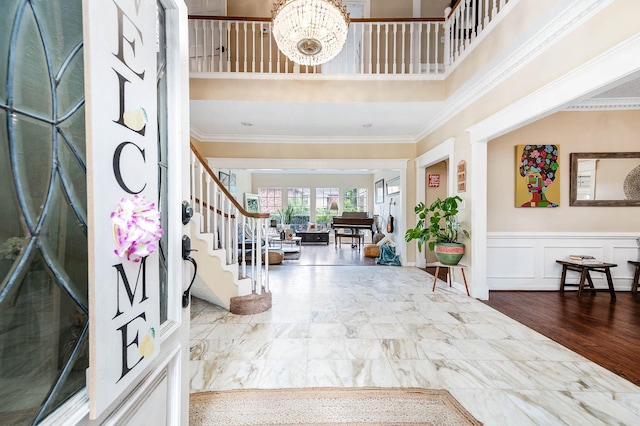 9911 Oxted Ln, Spring, TX 77379 - entryway with stairs, ornamental molding, a chandelier, a wainscoted wall, and a decorative wall