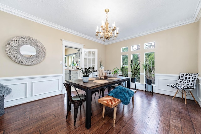 9911 Oxted Ln, Spring, TX 77379 - dining room with a chandelier, crown molding, a wainscoted wall, dark wood-style floors, and a decorative wall