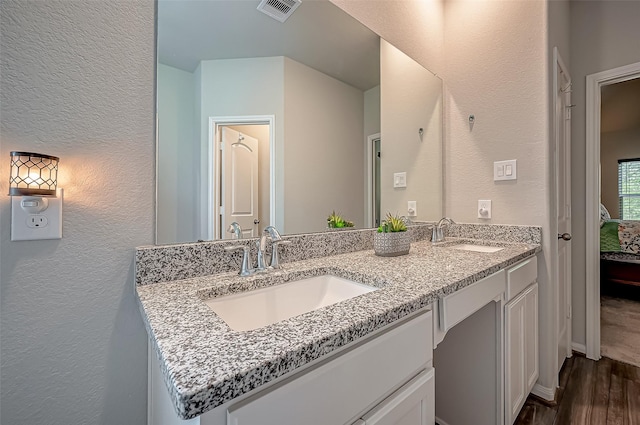 15055 Meadow Gln N, Conroe, TX 77306 - full bath with a textured wall, double vanity, wood finished floors, and connected bathroom