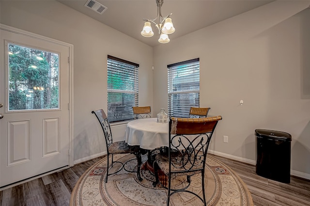 15055 Meadow Gln N, Conroe, TX 77306 - dining room featuring a chandelier, plenty of natural light, and wood finished floors