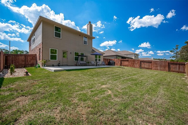 15055 Meadow Gln N, Conroe, TX 77306 - back of house with a chimney, a patio area, and brick siding