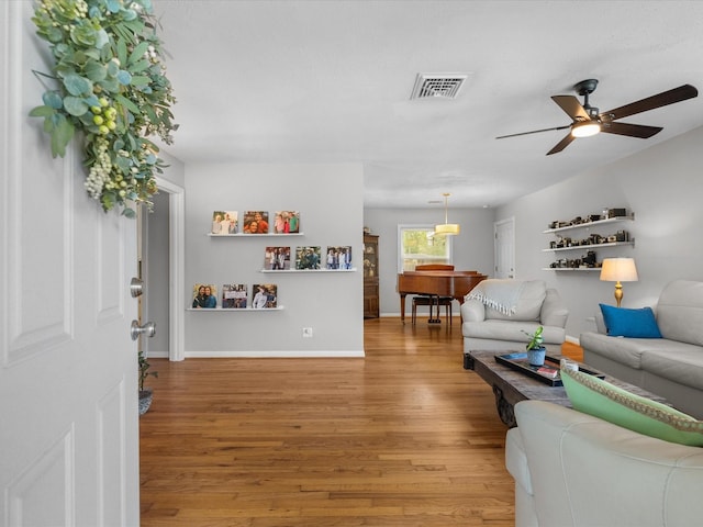 110 Marshall St, League City, TX 77573 - living room with light wood-style flooring, a ceiling fan, and baseboards