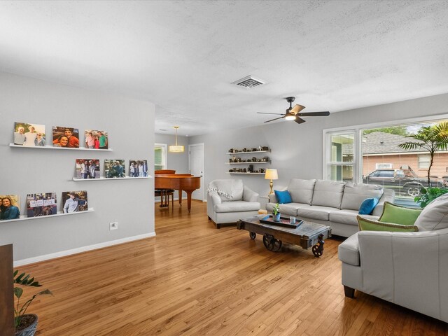 110 Marshall St, League City, TX 77573 - living area featuring light wood-type flooring, a ceiling fan, baseboards, and a textured ceiling