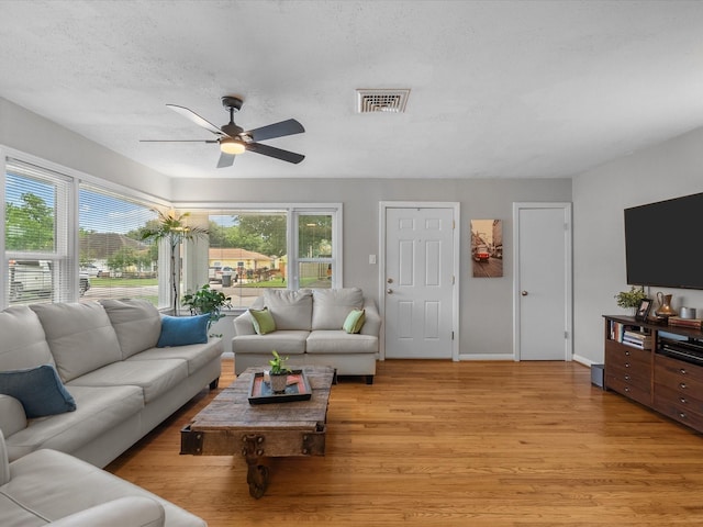 110 Marshall St, League City, TX 77573 - living area featuring ceiling fan, light wood finished floors, baseboards, and a textured ceiling