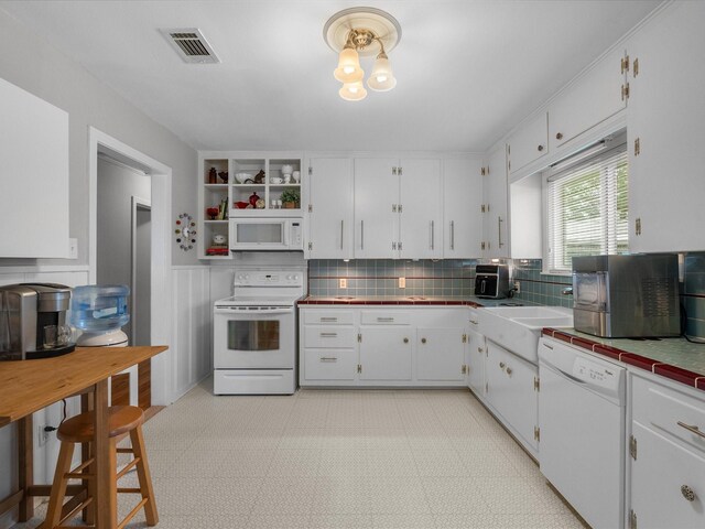 110 Marshall St, League City, TX 77573 - kitchen with white appliances, tile counters, white cabinets, and wainscoting